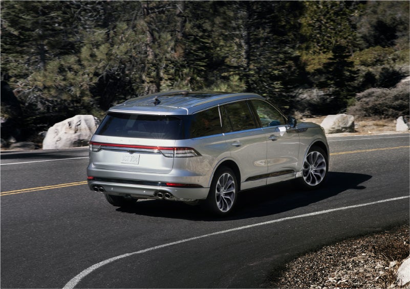 A 2023 Lincoln Aviator® Grand Touring model is shown being driven on a tight turn of a mountain road | Biondi Lincoln in Monroeville PA