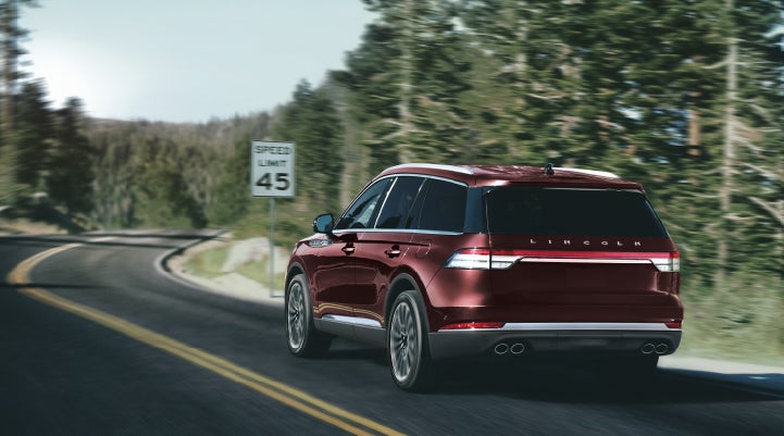A 2024 Lincoln Aviator® SUV is being driven on a winding mountain road | Biondi Lincoln in Monroeville PA