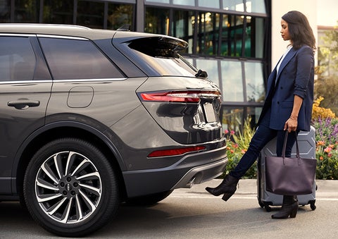 A woman with her hands full uses her foot to activate the available hands-free liftgate. | Biondi Lincoln in Monroeville PA