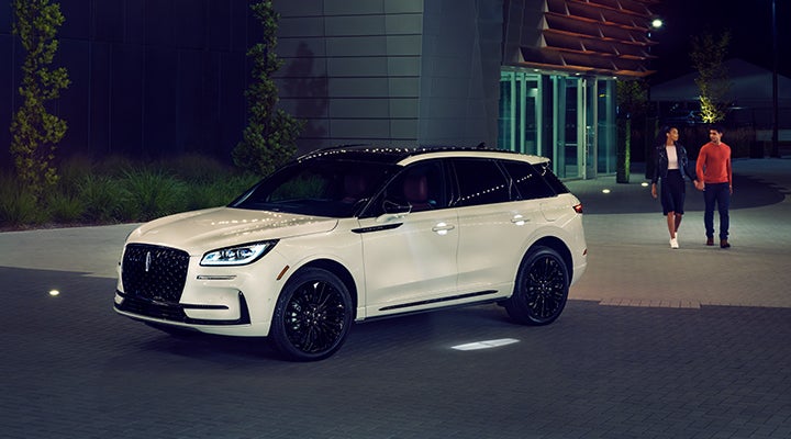 Two people approach a 2024 Lincoln Corsair® SUV featuring the available Jet Appearance Package. | Biondi Lincoln in Monroeville PA