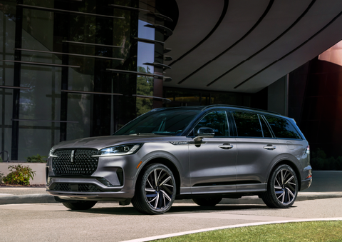 A gray 2025 Lincoln Aviator® SUV is parked outside a modern building showcasing the driver’s side of the vehicle. | Biondi Lincoln in Monroeville PA