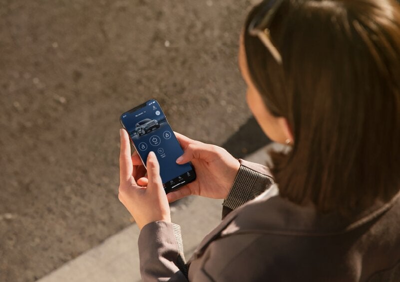A person is shown interacting with a smartphone to connect to a Lincoln vehicle via the Lincoln Way® App. | Biondi Lincoln in Monroeville PA