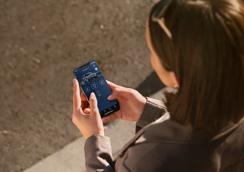 A person is shown interacting with a smartphone to connect to a Lincoln vehicle via the Lincoln Way® App. | Biondi Lincoln in Monroeville PA