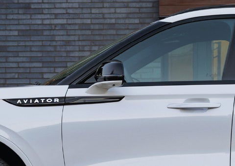 The driver’s side door and fender badging of a white 2026 Lincoln Aviator® SUV are showcased. | Biondi Lincoln in Monroeville PA