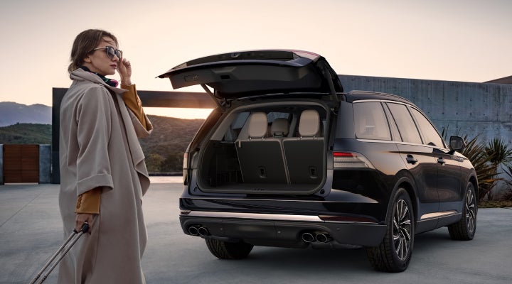 A woman approaches a 2026 Lincoln Aviator® SUV with its rear liftgate open. | Biondi Lincoln in Monroeville PA