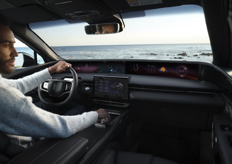 A driver of a parked 2026 Lincoln Nautilus® SUV takes a relaxing moment at a seaside overlook while inside his Nautilus. | Biondi Lincoln in Monroeville PA