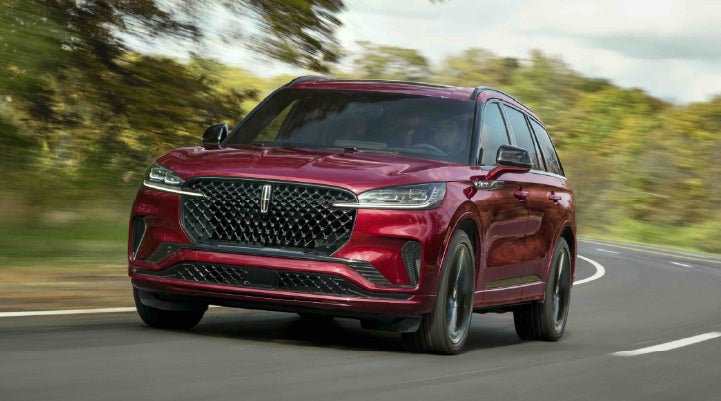 A 2027 Lincoln Aviator® SUV is being driven on a country road | Biondi Lincoln in Monroeville PA