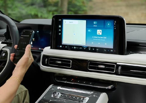 A person pairs thier phone with the center touchscreen of a 2027 Lincoln Aviator® Black Label™ SUV | Biondi Lincoln in Monroeville PA