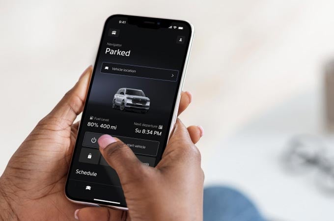 A man holding a phone viewing the Lincoln app.